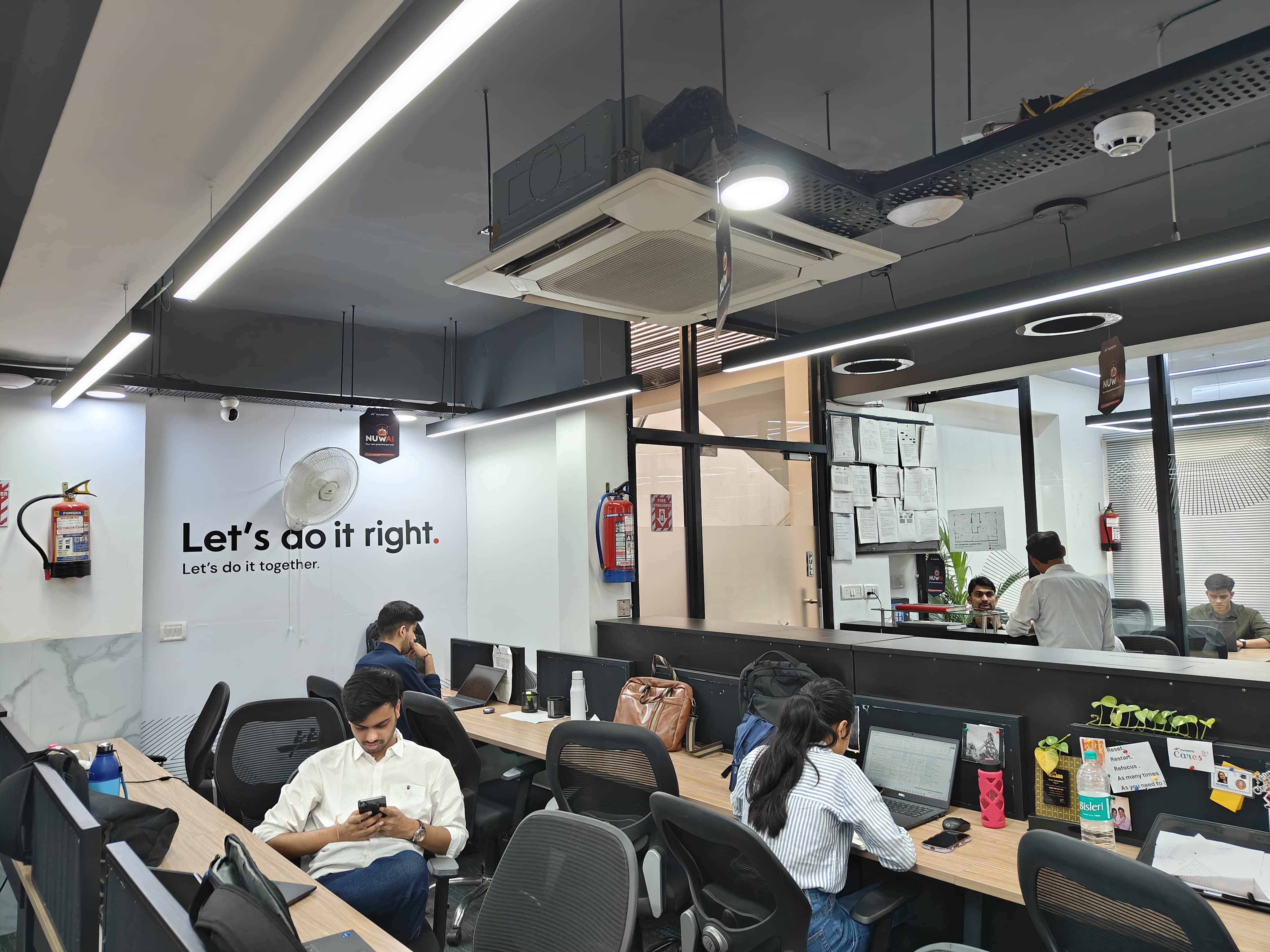 Team workspace with desks and partitions at AtWork FinTech